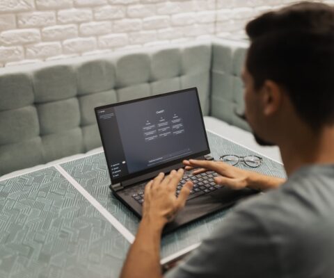 A man focused on his work, typing on a laptop computer